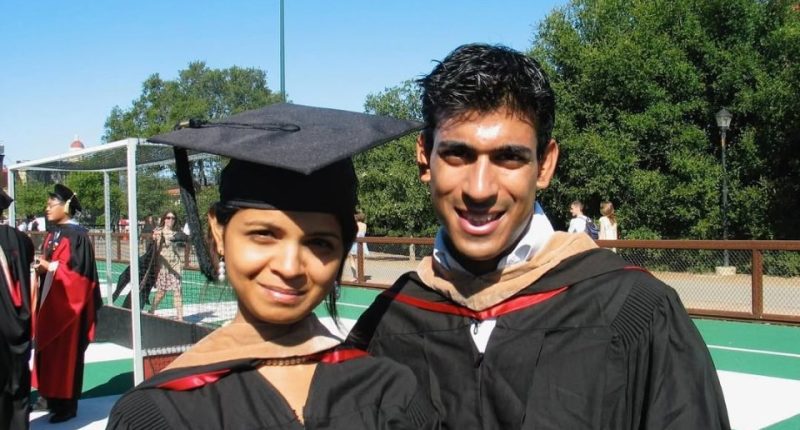 Two graduates in academic regalia.