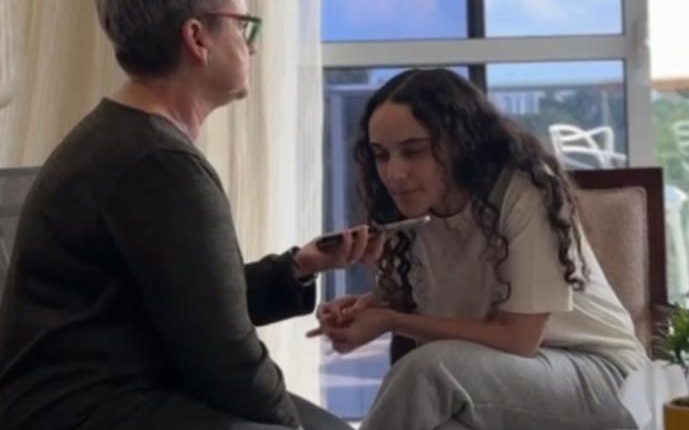 A woman being interviewed on a phone.