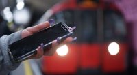 Woman using a phone on a London underground train.