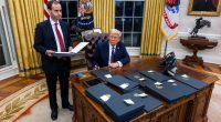 President Trump signing executive orders in the Oval Office.