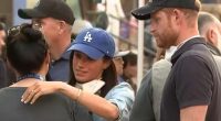 Prince Harry and Meghan Markle comforting a volunteer at a food distribution event.