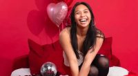 Woman smiling with heart-shaped balloons.