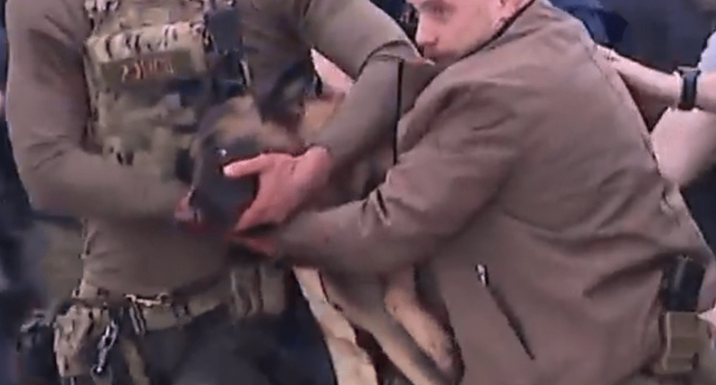 Police officers carrying an injured police dog.