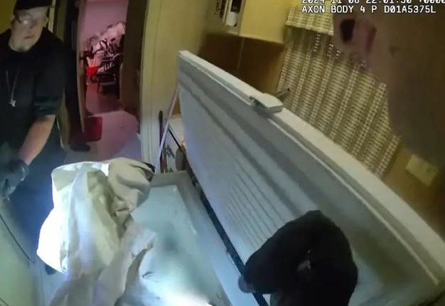 Police officers discovering a body in a freezer.