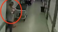 CCTV footage of a woman holding a baby in a hospital hallway.