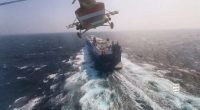 a helicopter is flying over a large ship in the ocean