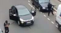Gunmen flee the offices of French satirical newspaper Charlie Hebdo in Paris in 2015