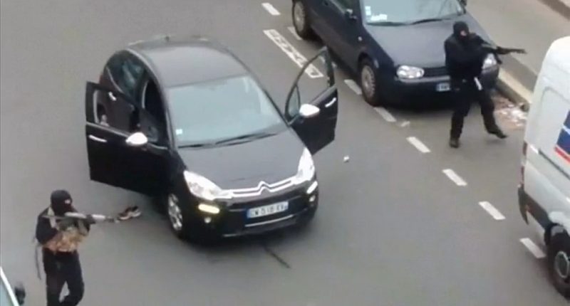 Gunmen flee the offices of French satirical newspaper Charlie Hebdo in Paris in 2015