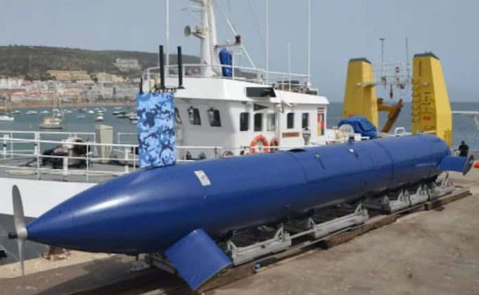 A large blue submarine drone on a transport vehicle.