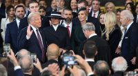 Donald Trump being sworn in as president, surrounded by family and onlookers.