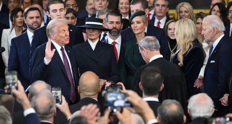 Donald Trump being sworn in as president, surrounded by family and onlookers.