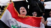 Iraqi woman protesting proposed law allowing underage marriage, holding Iraqi flag.