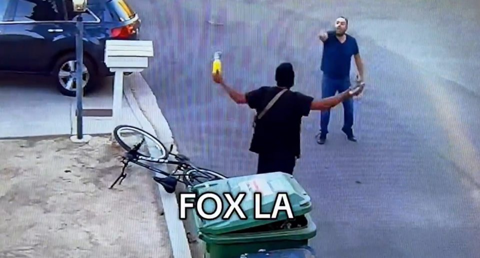 Video still of a man being apprehended by another man.