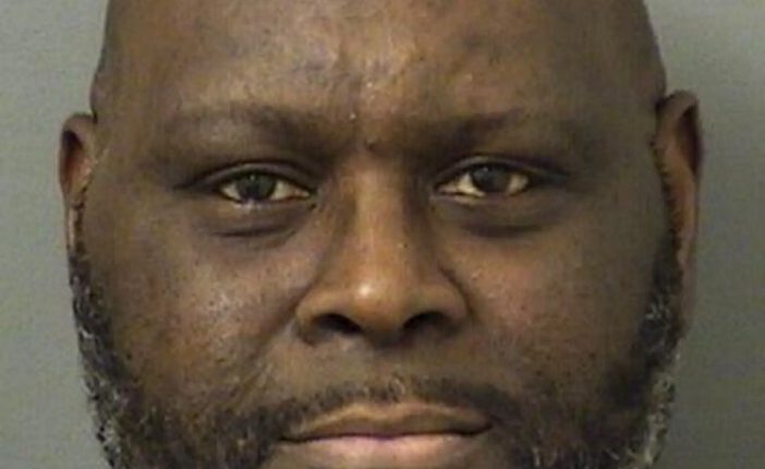 Mugshot of a bald, dark-skinned man with a goatee.