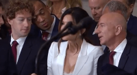Group of people seated, some looking at a woman speaking into a microphone.