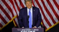 Donald Trump speaking at a podium in front of American flags.