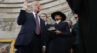 Donald Trump being sworn in as president, with Melania Trump holding a Bible.