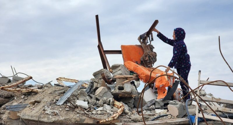 Child amidst rubble of a destroyed building.