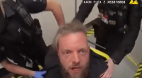 A man being removed from a plane by police officers.
