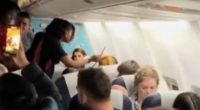 The footage shows a flight attendant appear with plastic restraints