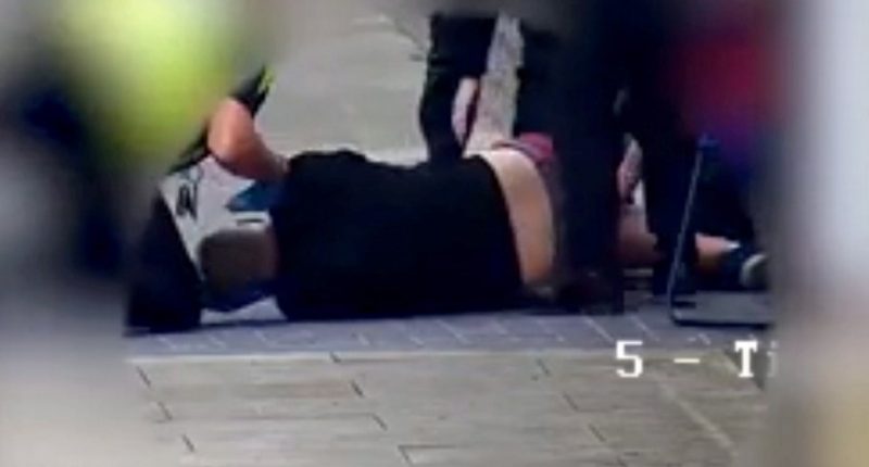 Photo of a man lying on the ground after being injected with a drug.