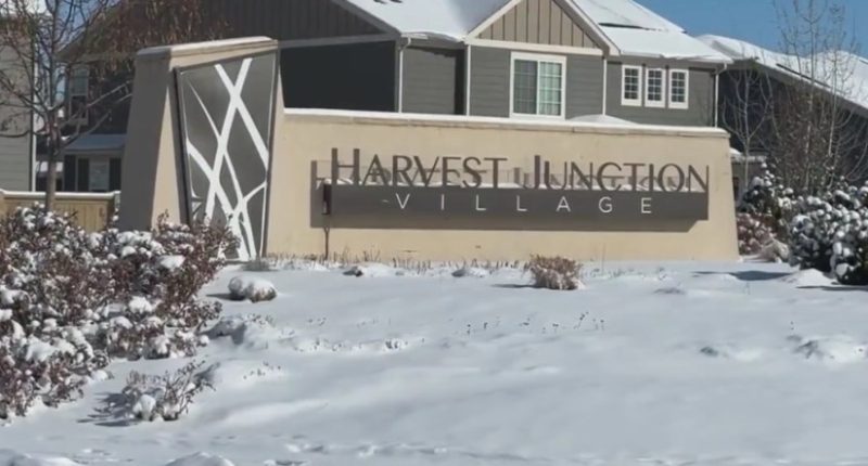 Snow-covered Harvest Junction Village sign.