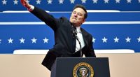 Elon Musk giving a speech at an inauguration, making a hand gesture.