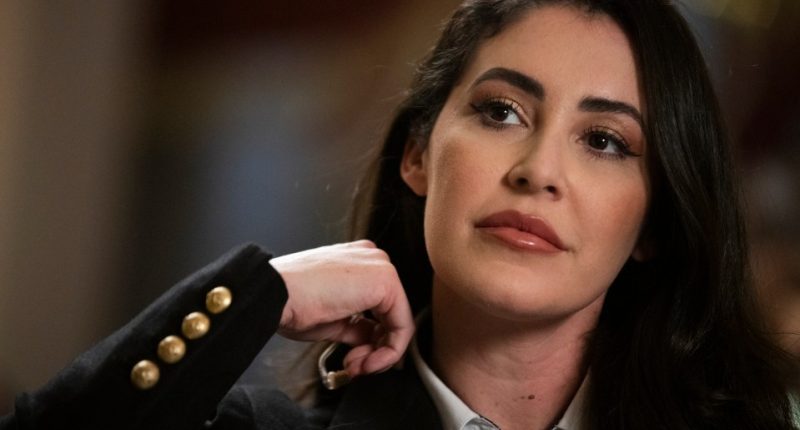 Anna Paulina Luna removing her microphone after an interview.