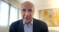 Man in suit speaking to camera.