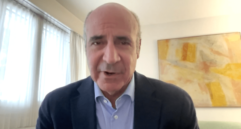 Man in suit speaking to camera.