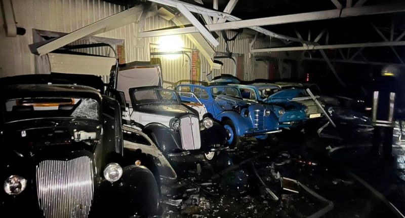 Bombed classic cars in a damaged building.
