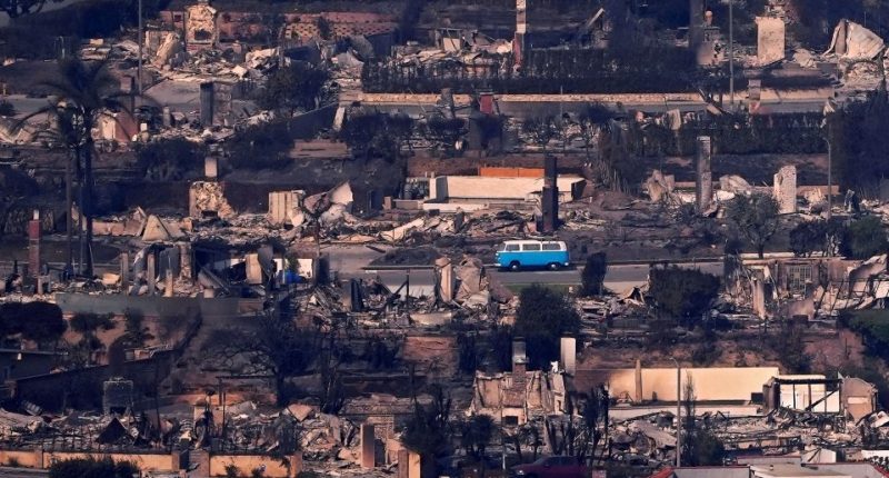 A blue van amidst fire-damaged homes.