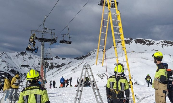 Firefighters rescue skiers from a chairlift at a ski resort.