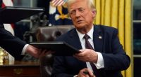 President Donald Trump signing executive orders in the Oval Office.