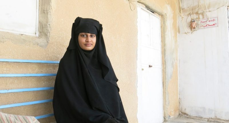 Shamima Begum, a young woman in a niqab, sits on a bench.