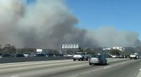Cars flee Los Angeles as smoke from the wildfires take over the sky