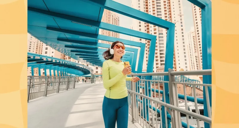fit woman jogging across bridge for exercise