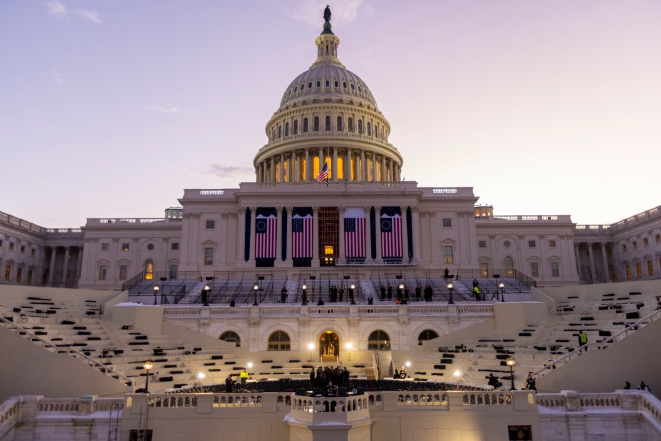 US Capitol building at sunrise with seating set up for a presidential inauguration rehearsal.