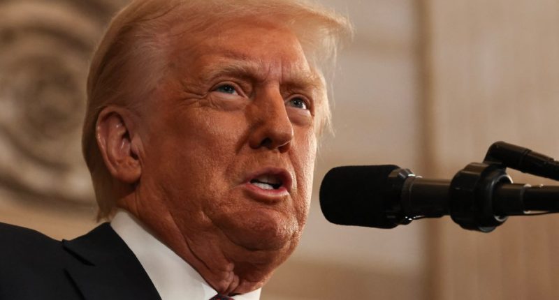 Close-up of Donald Trump speaking into a microphone.