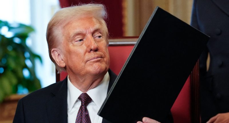 President Donald Trump reviewing a document.