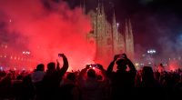 Crowd watching fireworks display in front of Milan Cathedral.