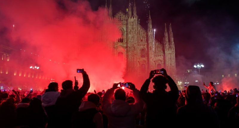 Crowd watching fireworks display in front of Milan Cathedral.