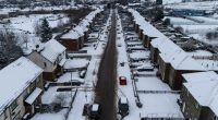 Aerial view of a snow-covered village street in Lancashire.