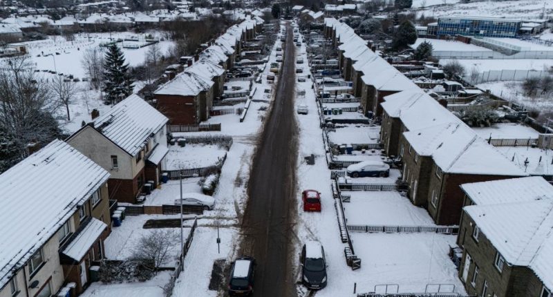 Aerial view of a snow-covered village street in Lancashire.