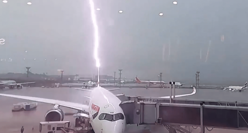 Lightning striking an airplane at an airport.