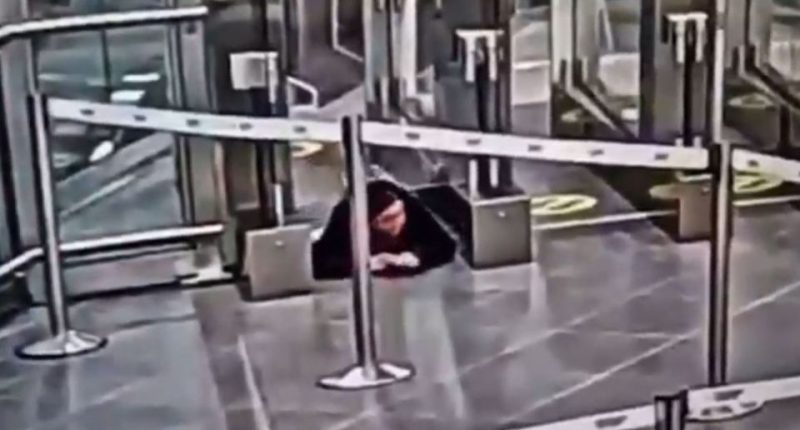 Security footage of a woman crawling under an airport security barrier.