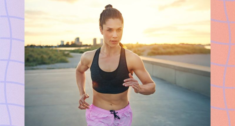 fit brunette woman in pink shorts and black sports bra running outdoors at sunset