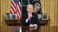 President Biden speaking at a table in the Oval Office.