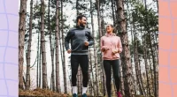 fit couple smiling and looking at each other as they prepare to go for a light jog or brisk walk in the woods