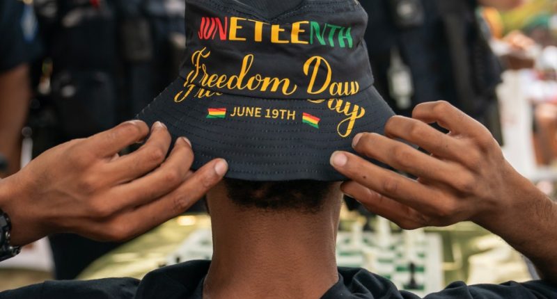 An attendee adjusts his Juneteenth-themed hat during a neighborhood Juneteenth festival on June 17, 2023 in Washington, DC.